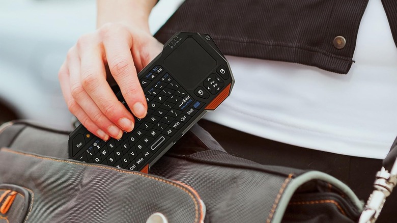 Woman sliding a mini keyboard into a shoulder bag