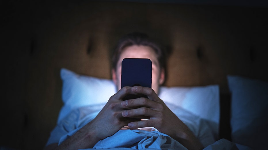 Anonymous Man Uses Smartphone in Bed
