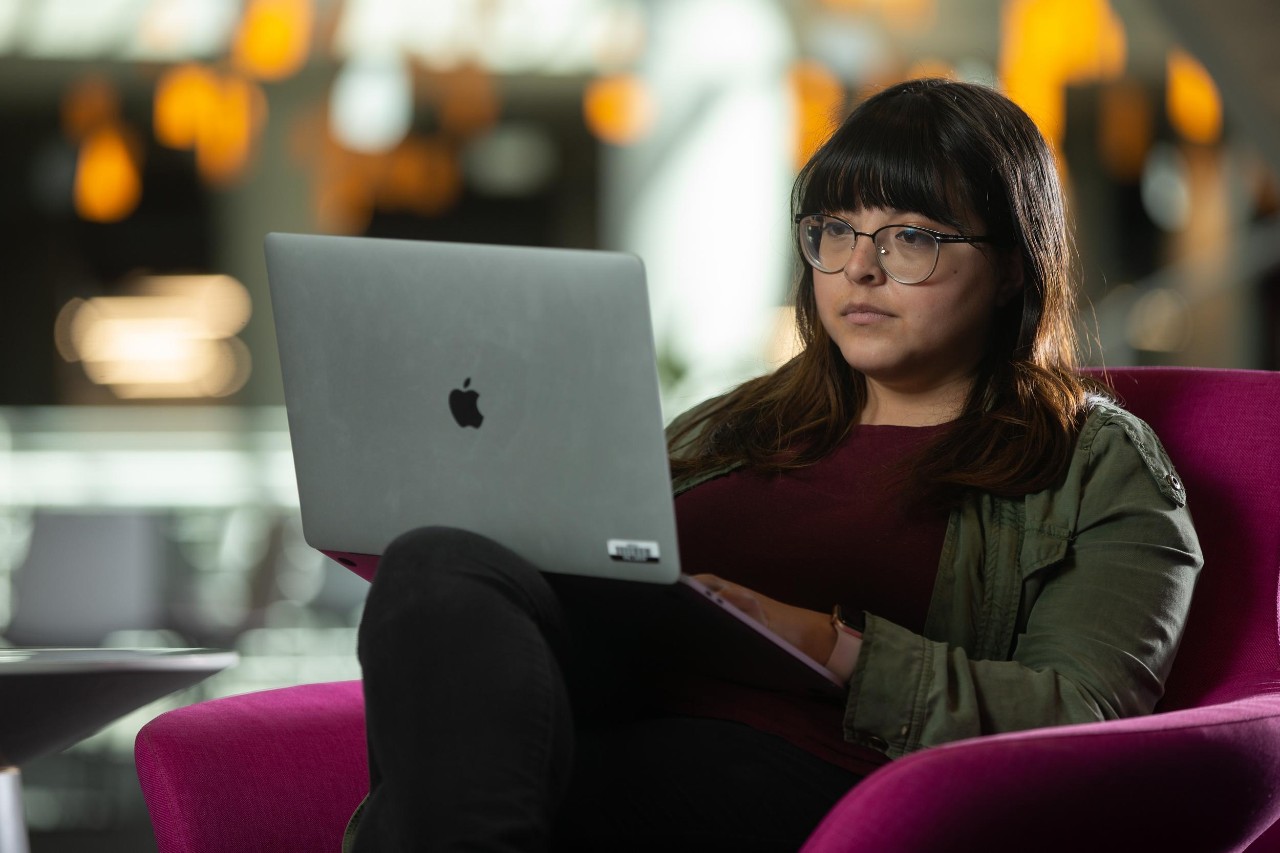Woman working on a computer at UC. Photo/Andrew Higley