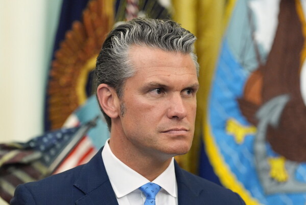 Defense Secretary Pete Hegseth listens as President Donald Trump speaks during a meeting about military families, in the Oval Office of the White House, Monday, Aug. 3, 2026, in Washington. (AP Photo/Alex Brandon)